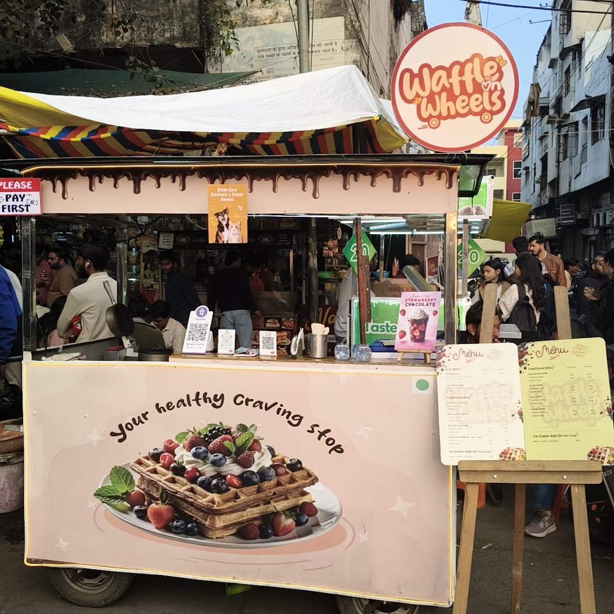 The pink Waffle on Wheels cart in MP Nagar with its menu board